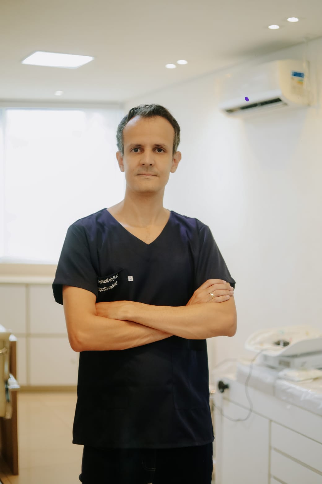 Dr. Alyrio Mourão no consultório, postura confiante